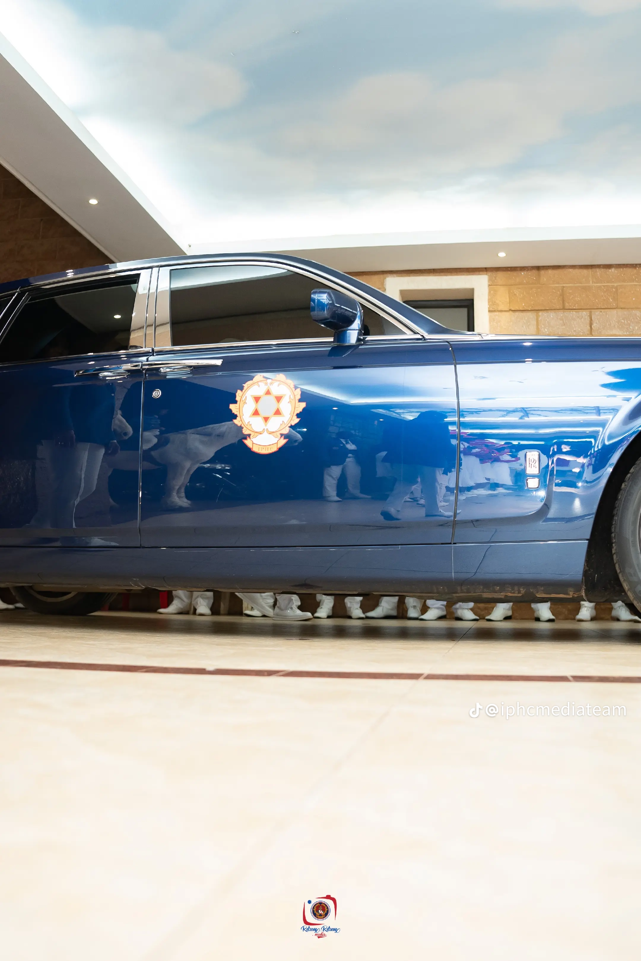 Side view of a dark blue vehicle displaying the IPHC crest