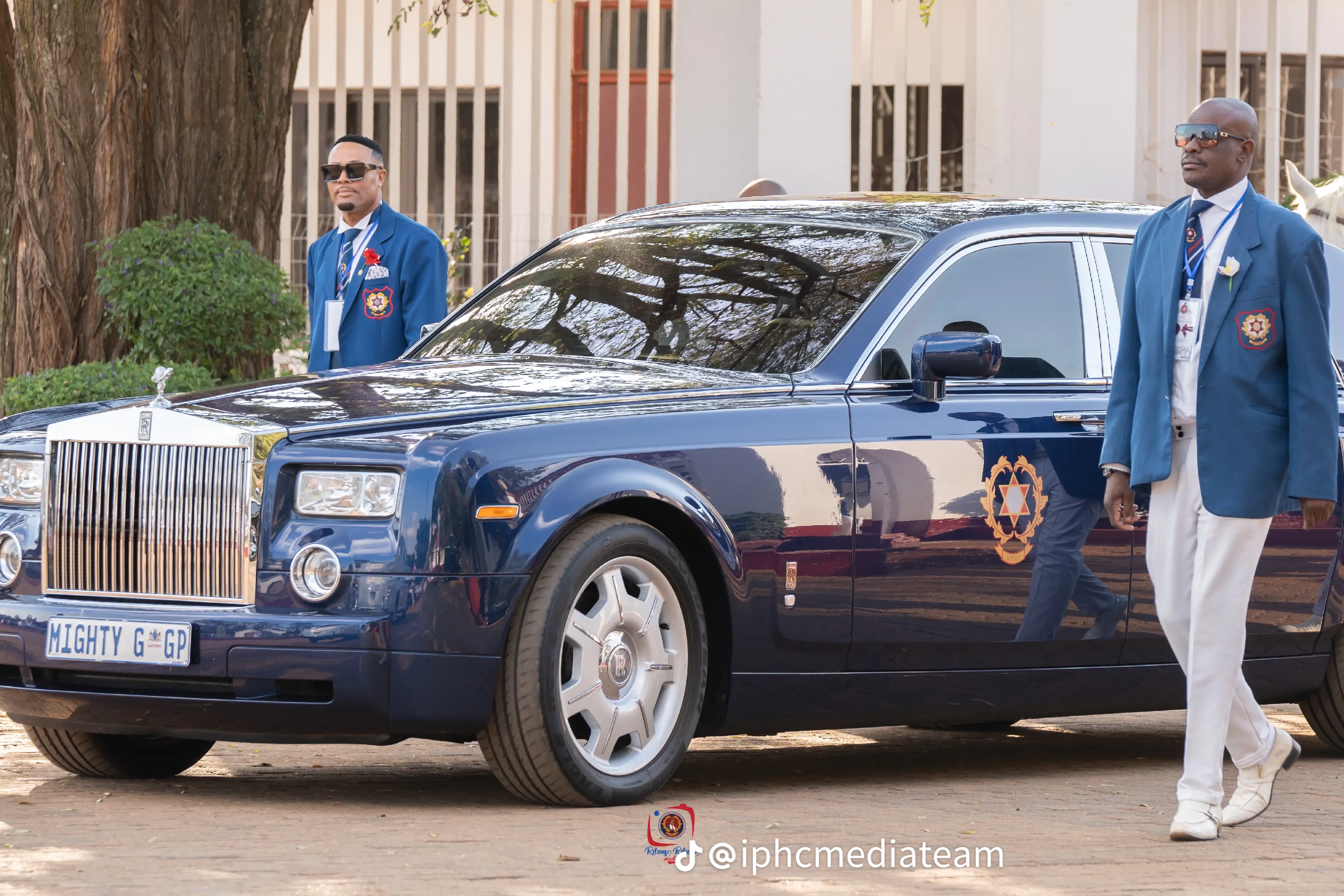 IPHC crest on a blue Rolls-Royce beside uniformed attendants